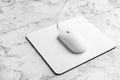 Modern wired optical mouse and pad on marble table Royalty Free Stock Photo