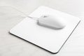 Modern wired optical mouse and pad on wooden table Royalty Free Stock Photo