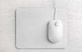 Modern wired optical mouse and pad on wooden table, top view Royalty Free Stock Photo