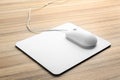 Modern wired optical mouse and pad on table Royalty Free Stock Photo