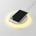 Modern wireless charger with soft ambient lighting for smartphones Royalty Free Stock Photo