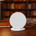 Modern Wireless Charging Pad on Library Desk Royalty Free Stock Photo