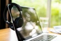 Modern wireless headphone hanging over laptop