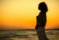 Modern woman on beach in evening looking into distance Royalty Free Stock Photo