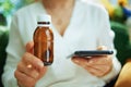 Modern woman buying pharma in living room in sunny day