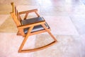 A modern wood rocking chair on colored cement floor Royalty Free Stock Photo