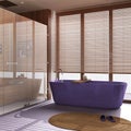 Modern wooden bathroom in purple and beige tones. Freestanding bathtub and shower with glass door and marble tiles floor. Royalty Free Stock Photo