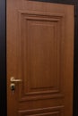 Modern wooden brown door with metal door handle Royalty Free Stock Photo