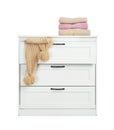 Modern wooden chest of drawers with clothes on white Royalty Free Stock Photo