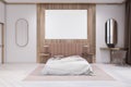 Modern wooden and concrete stylish hotel bedroom interior with empty white mock up poster. Design concept. Royalty Free Stock Photo