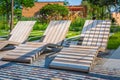 Modern wooden deck chairs or chaise longues for patio or garden Royalty Free Stock Photo