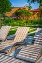 Modern wooden deck chairs or chaise longues for patio or garden Royalty Free Stock Photo