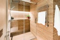 Modern wooden-effect bathroom with glass shower cabin and heated towel rail Royalty Free Stock Photo
