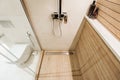 Modern wooden-effect bathroom with glass shower cabin and white toilit Royalty Free Stock Photo