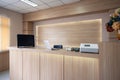 Modern wooden reception counter with monitor, laptop and electronic device in hospital
