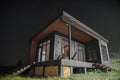 Modern wooden tiny cabin at night with sky full of stars