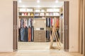 Modern wooden wardrobe with clothes hanging on rail in walk in closet Royalty Free Stock Photo