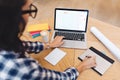 Modern work image young brunette woman in black glasses from back working with laptop on table. Creativity, graphic