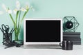 Modern workplace with blank computer display, black stationery, books, coffee cup, abstract atom model, white  bouquet in green. Royalty Free Stock Photo