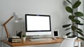 Modern workplace with blank computer screen, lamp and supplies on wooden desk. Empty screen for your advertising design Royalty Free Stock Photo