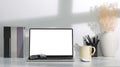 Modern workplace with computer laptop, books, coffee cup and pencil holder on white table Royalty Free Stock Photo