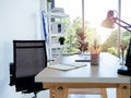 Modern workplace with empty black chair, pencil, notebook table lamp and laptop computer. Royalty Free Stock Photo