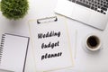 Modern workplace with laptop and wedding budget planner