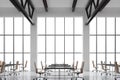 Modern workplaces in a modern bright clean interior of a loft style office. Huge windows with copy space and white walls. Black de Royalty Free Stock Photo