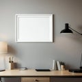 Modern workspace with blank frame, desk lamp, and office supplies on wooden desk against a grey wall Royalty Free Stock Photo