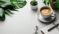 Modern workspace with a cup of coffee, a notebook, glasses, and green plants on a white desk. Minimalistic office setup Royalty Free Stock Photo