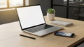 Modern workspace featuring a laptop with a blank screen on a wooden Royalty Free Stock Photo