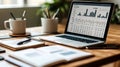 close up of a modern laptop displaying financial charts and data on a wooden desk with office supplies and coffee cup Royalty Free Stock Photo