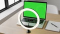Modern workspace with laptop, ring light, notebook, and pen on wooden desk Royalty Free Stock Photo