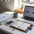 Modern workspace with laptop showing analytics charts and notebook Royalty Free Stock Photo