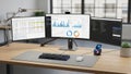 Modern workspace with multiple monitors and data analytics Royalty Free Stock Photo