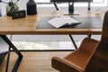 Modern workspace setup with an open notebook on a wooden desk in a bright office environment Royalty Free Stock Photo