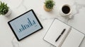 Modern Workspace Setup with Tablet Displaying Bar Chart Data Analysis and Coffee Cup Royalty Free Stock Photo