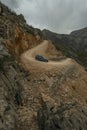 Modern 4x4 vehicle going down a steep dirt track through