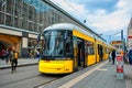 Modern yellow city tram at a public transport stop