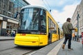 Modern yellow city tram at a public transport stop