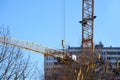 Modern yellow construction crane on a blue sky background is building a new house, concept, housing construction concept, mortgage Royalty Free Stock Photo