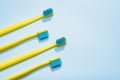 Modern yellow kids toothbrushes on a blue background. Copy space for your text