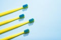 Modern yellow kids toothbrushes on a blue background. Copy space for your text