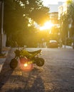 Modern yellow motorcycle parked near a street during sunset in Playa Del Carmen city, Mexico