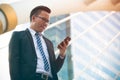 Modern young businessman wear black suit hand holding smartphone. Professional business man standing outside office Royalty Free Stock Photo