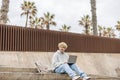 Modern young caucasian guy using his laptop and looking at distance at day time.