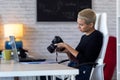 Modern young entrepreneur woman reviewing her last photographs in the camera while sitting in the office Royalty Free Stock Photo