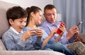 Family absorbedly looking at smartphones Royalty Free Stock Photo