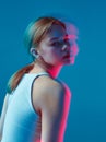 Modern young girl in colorful neon light, studio portrait with long exposure. Beauty, skincare, haircare concept Royalty Free Stock Photo