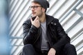 Modern young man talking on the phone with hands free in the street. Royalty Free Stock Photo